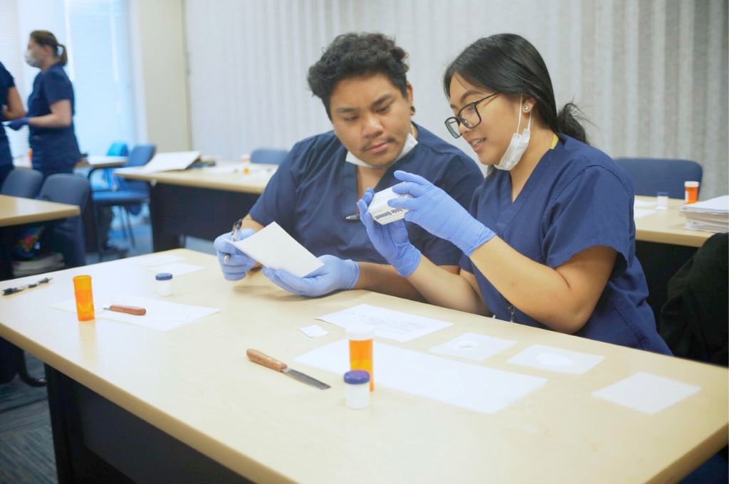 Pharmacy Techncians in training learning how to identify prescriptions on pill bottles.